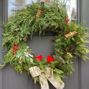 Christmas wreath with green cedar and red holly with cinammon sticks on a door in Blaine, Washington