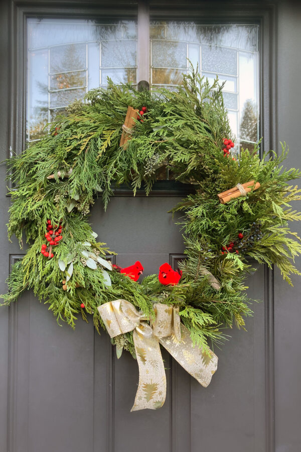 Christmas wreath with green cedar and red holly with cinammon sticks on a door in Blaine, Washington